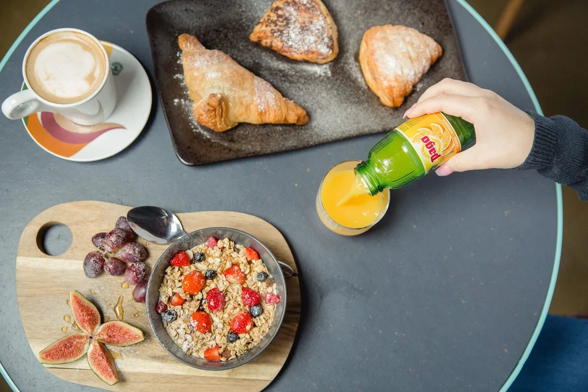 Pago Orange bij een verzorgd ontbijt met koffie, croissants en granola